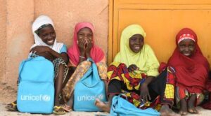 Výbava do školy pro 3 chudé dívky (3 školní batohy, 60 tužek, 60 sešitů).